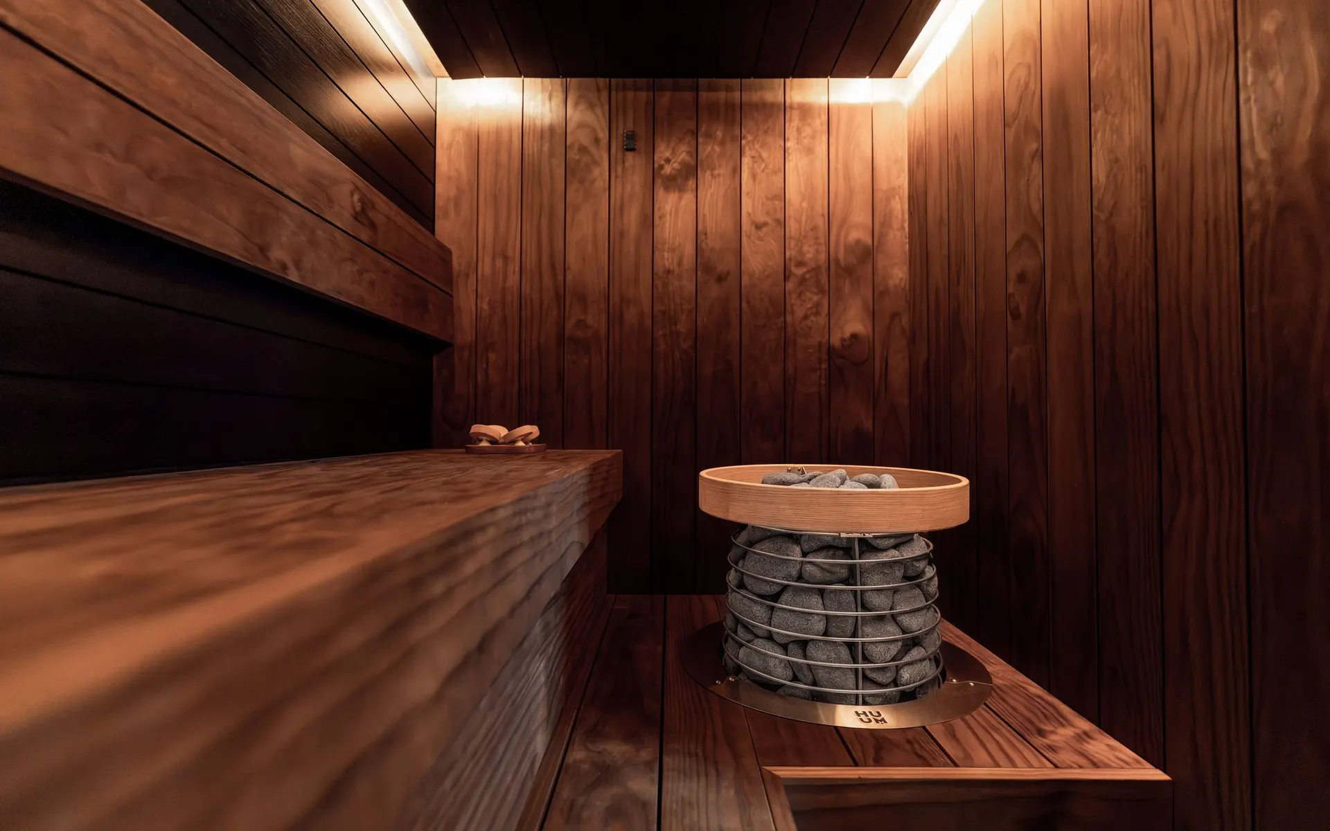 Remontoitu sauna tummilla paneeleilla ja lauteilla